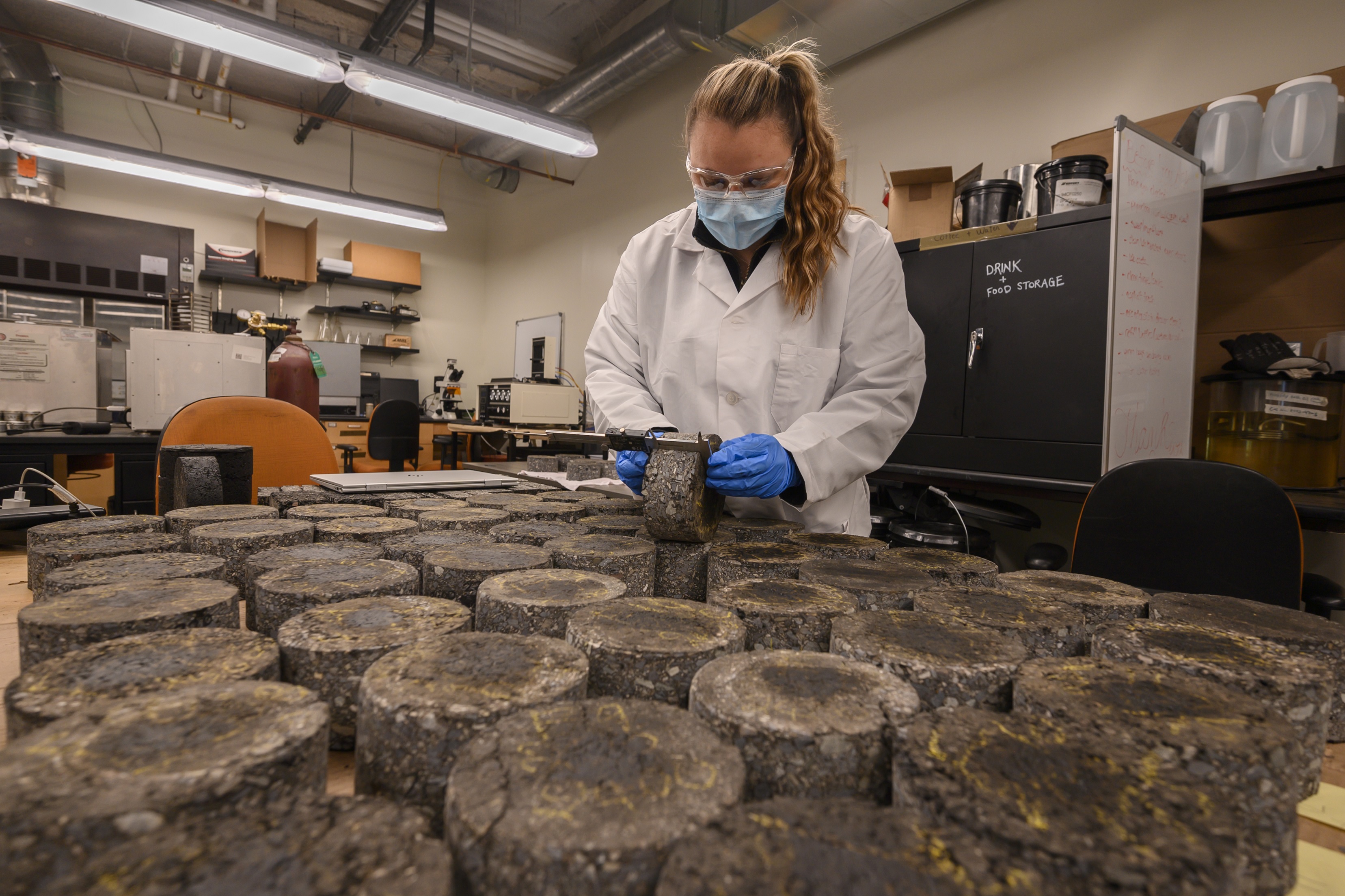 Kayleigh McDevitt measures asphalt samples inside the lab at Rowan University.