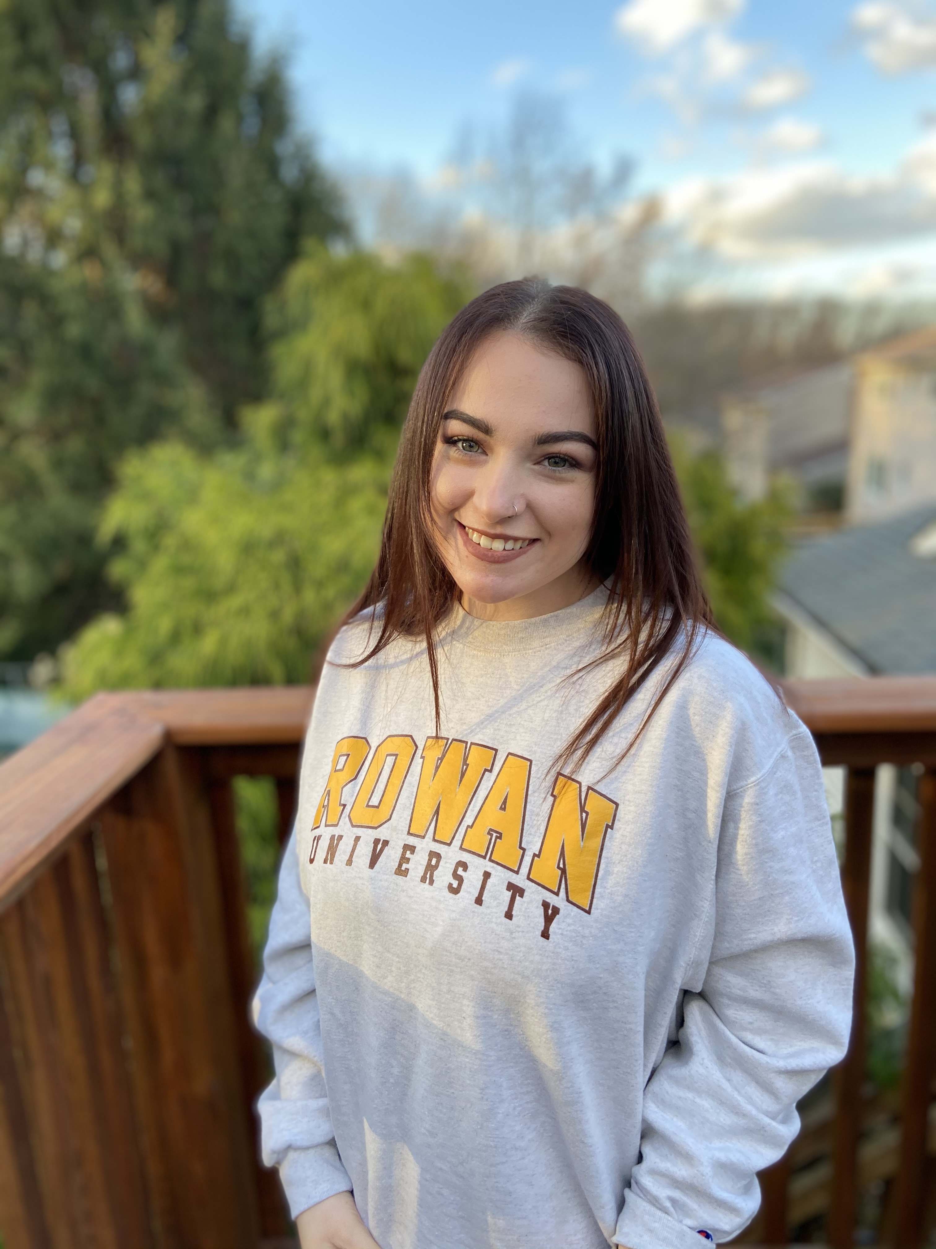 Jenna Bottiglieri poses outside for a portrait while wearing a Rowan University sweatshirt.