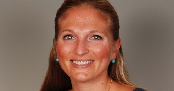 This is a portrait of Dr. JoAnne Bullard, a white woman with long blonde hair. She is smiling and looking straight at the camera.