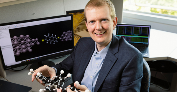 Erik Hoy holding a model of a chemical compound