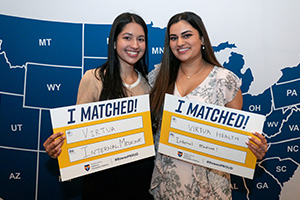 two SOM medical students show match day signs for VIrtua