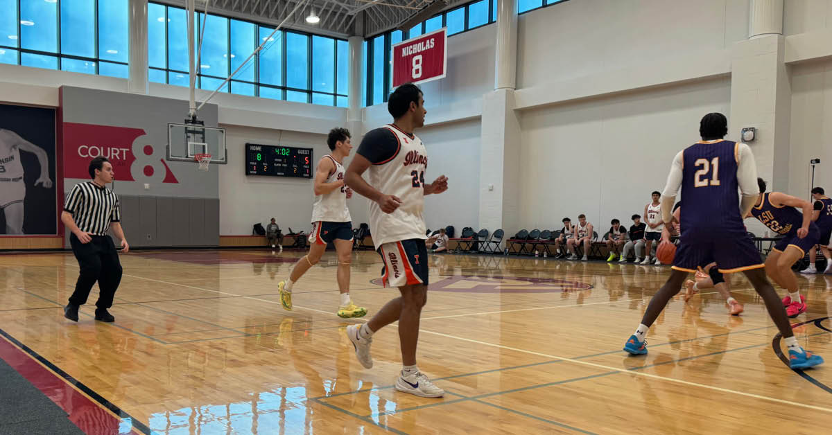 basketball official jogs along court following a play between two teams