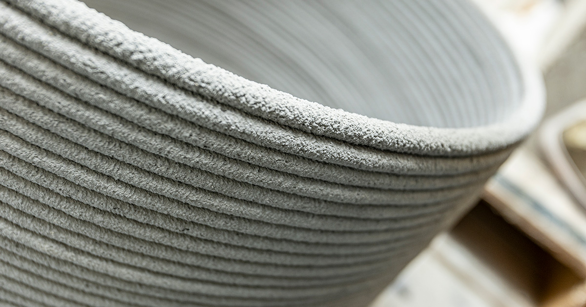 Coiled layers of rope-like 3D printed concrete show the material's naturally rough surface.