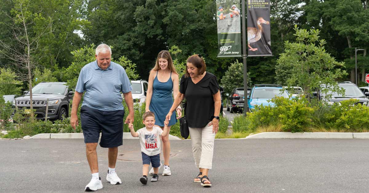 A family walks through the parking lot at Edelman Fossil Park.