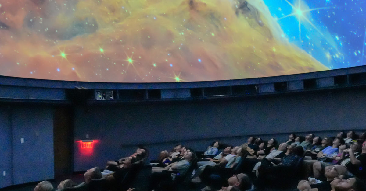 Guests at the Edelman Planetarium gaze up.