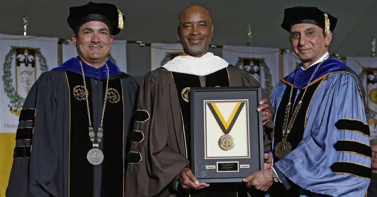 Virtua Health President and CEO, Dennis W. Pullin, receives a medal of excellence from Chancellor Lowman and President Houshmand.